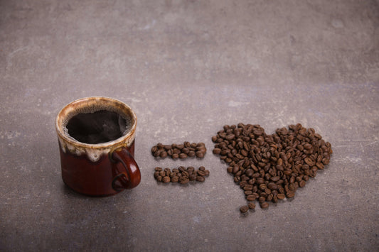 Coffee beans beside a ceramic cup