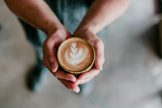 A person holding a cup of coffee, photo by David Fanuel on Unsplash
