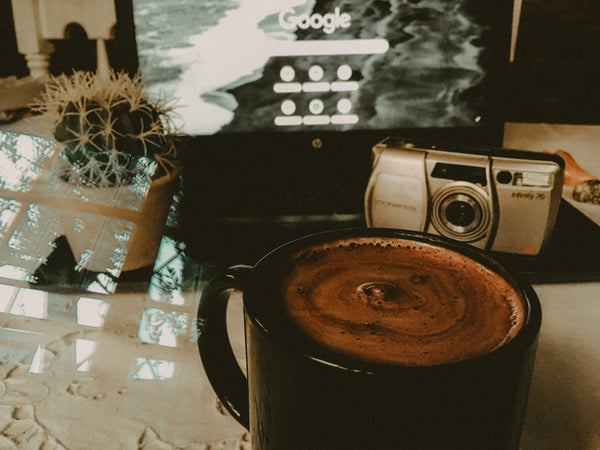 A black ceramic cup filled with coffee