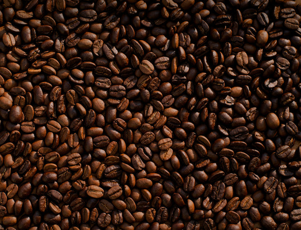Raw coffee beans scattered across a surface