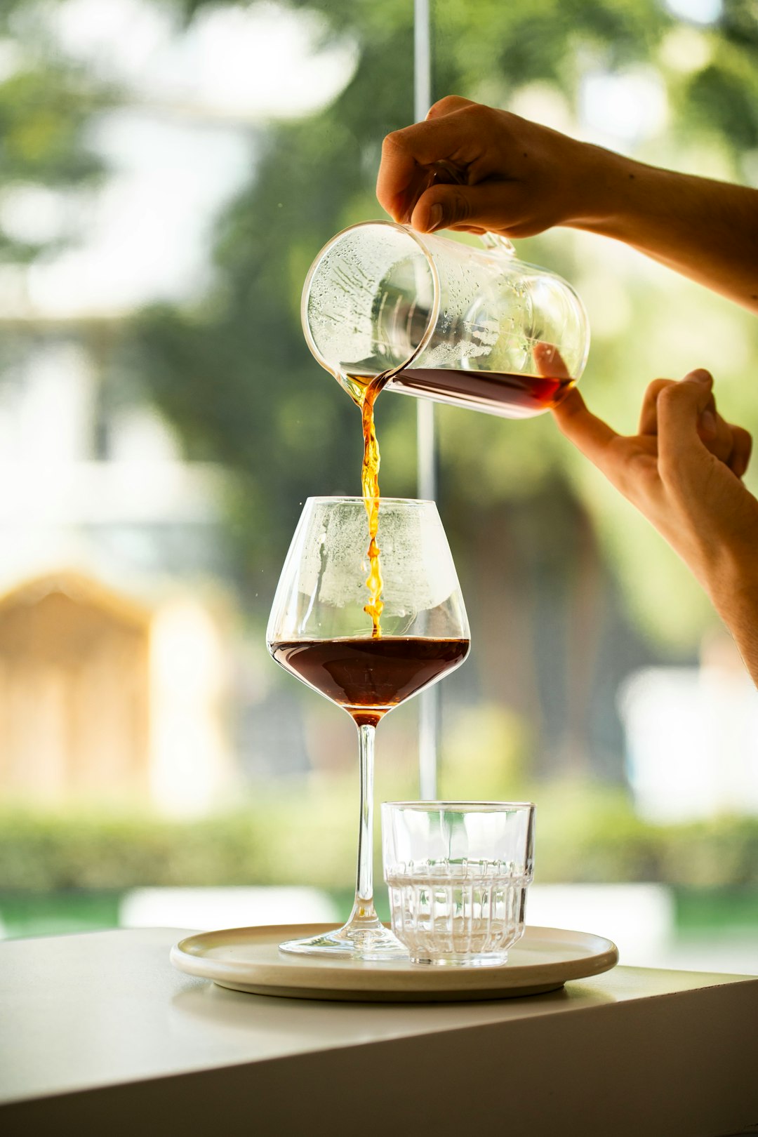 Coffee pouring into a glass in warm afternoon light